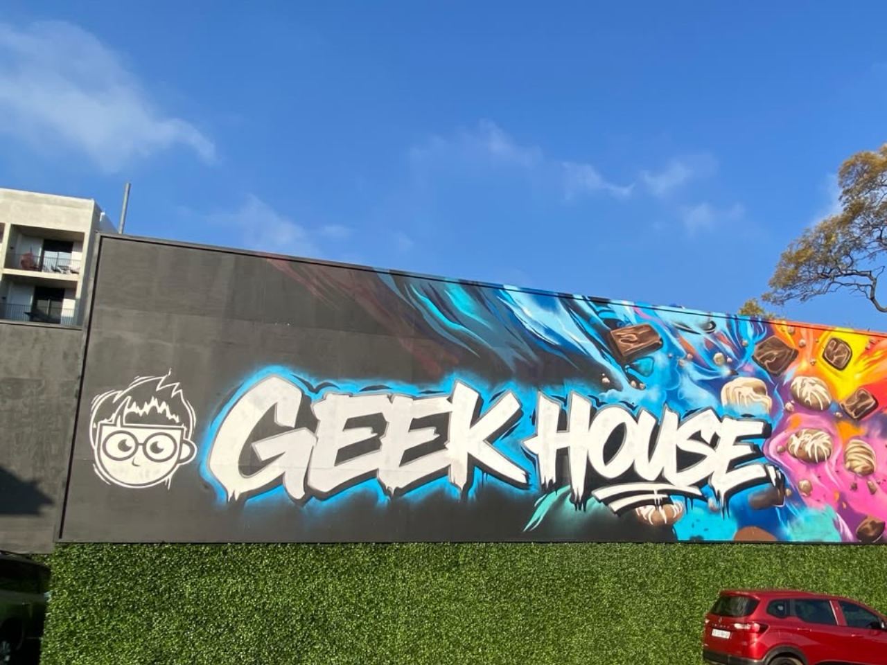 Geek House Eatery exterior mural with graffiti lettering and chocolate splash artwork