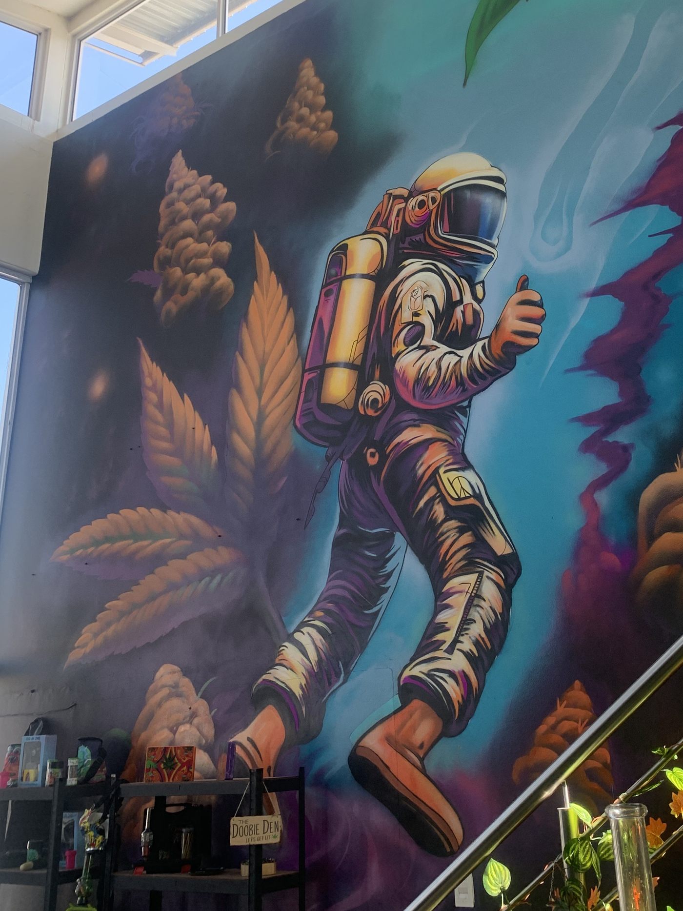Astronaut drifting between painted clouds on an interior mural