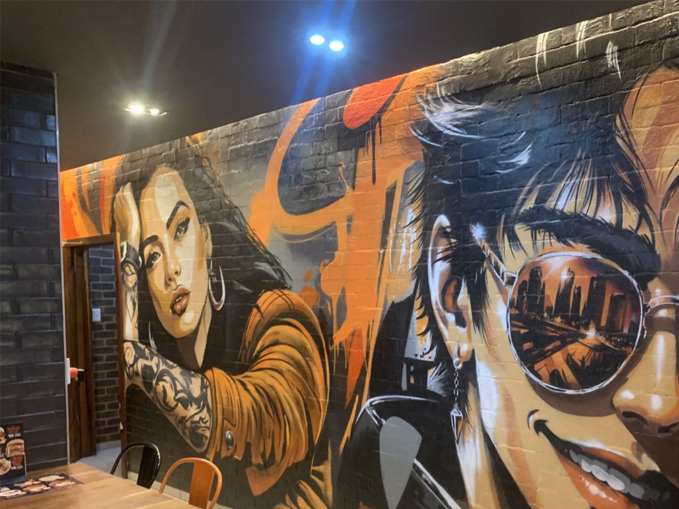 Two large spray-painted portraits on a RocoMamas retail store wall